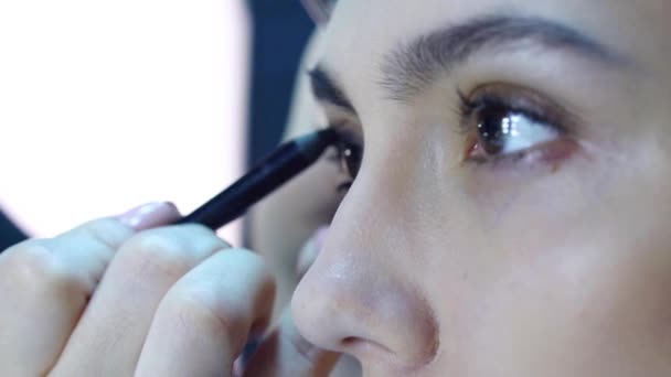 Maquillaje artista aplicar maquillaje a un atractivo jóvenes mujeres . — Vídeo de stock