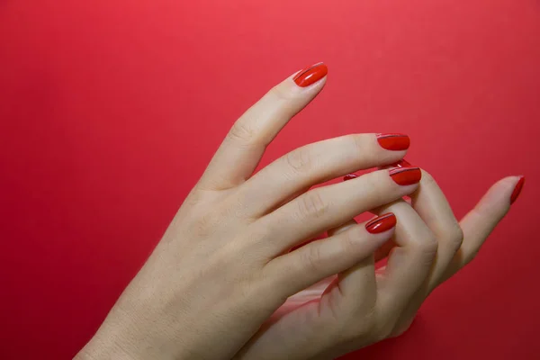 Belle mani femminili con manicure rossa e chiodo isolato — Foto Stock