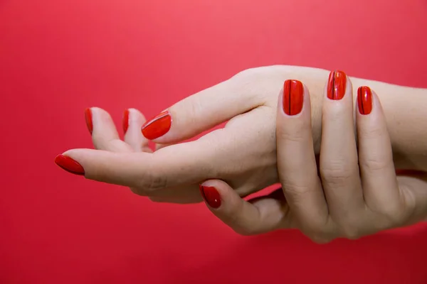 Piękne, kobiece ręce z paznokci i manicure czerwony na białym tle — Zdjęcie stockowe