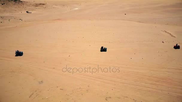 Skyline Vista aérea de hombres jóvenes montando quads sobre dunas de arena en el desierto . — Vídeo de stock