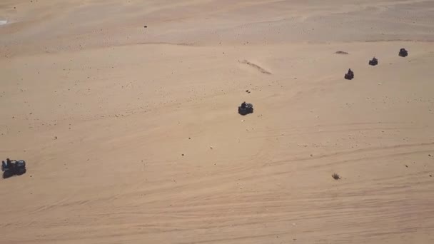 沙漠中的沙丘上骑四辆自行车的年轻人的天际线鸟瞰图. — 图库视频影像