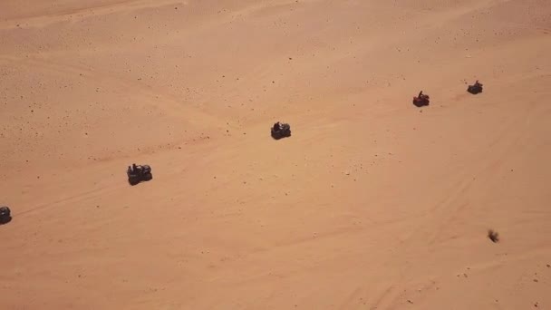 沙漠中的沙丘上骑四辆自行车的年轻人的天际线鸟瞰图. — 图库视频影像