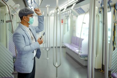 CoVid 'i korumak için maskesi olan Asyalı bir yolcu - 19, trende tableti var..