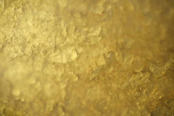 Cáscara dorada bajo papel de calco. textura dorada como fondo —  Fotos de Stock