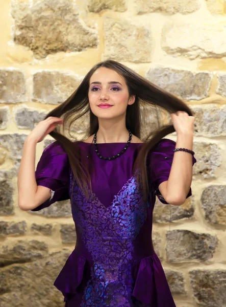 Mooie mode meisje op de achtergrond van de stenen muur — Stockfoto
