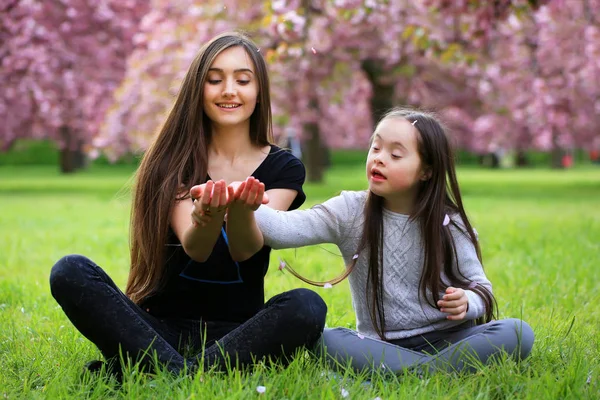 Joyeux belle jeune femme avec fille dans le parc de fleurs — Photo