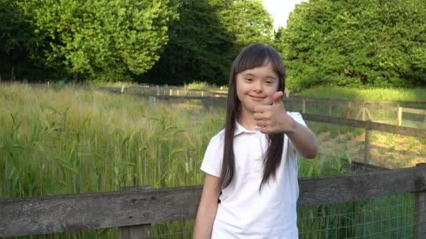 Down síndrome menina dando polegares para cima — Vídeo de Stock