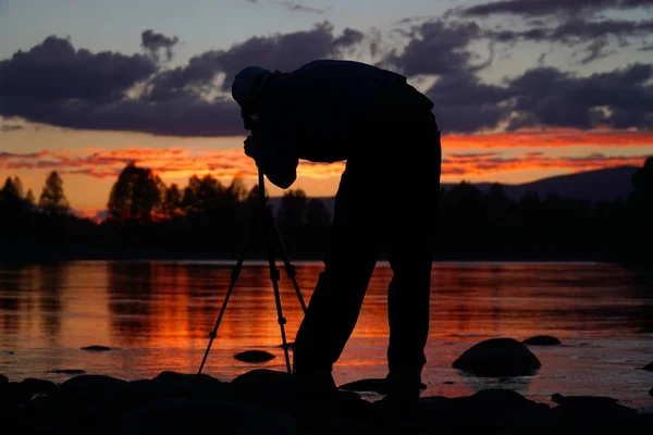 夕暮れ時、川の写真を撮る、ショットのフレーミングの写真家のシルエット — ストック写真