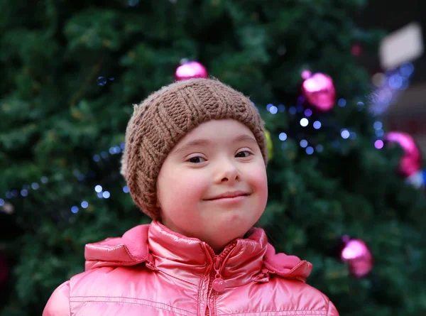 Menina no fundo da árvore de natal — Fotografia de Stock