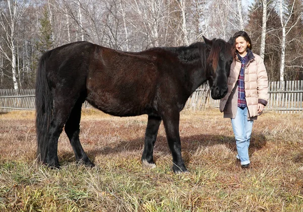 Bella giovane donna con un cavallo in campagna — Foto Stock