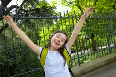 Parkta gülümseyen küçük kızın portresi.