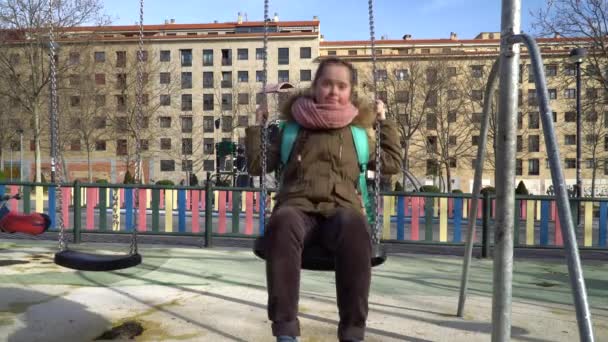 Klein meisje met down syndroom hebben plezier op de schommel — Stockvideo