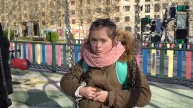 Down sendromlu küçük kız salıncakta eğleniyor.