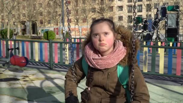 Klein meisje met down syndroom hebben plezier op de schommel — Stockvideo