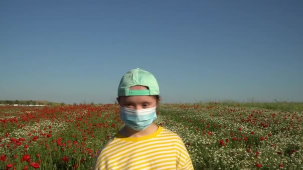 女の子でマスクで彼女の顔上の背景に花のフィールド — ストック動画