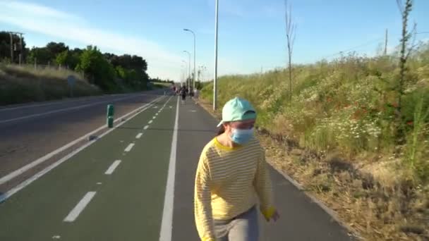 道路を走っている彼女の顔にマスクの女の子 — ストック動画
