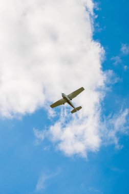 Mavi bir gökyüzü arka plan bulutlar üzerinde küçük motorlu uçakta