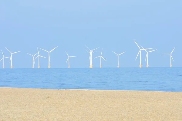 Parque eólico con playa de arena en primer plano — Foto de Stock