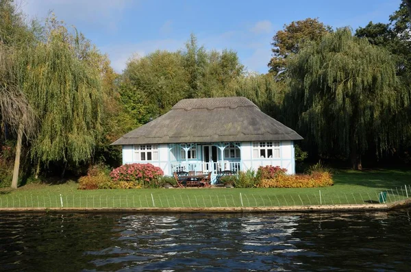Bílý a modrý dům u řeky — Stock fotografie