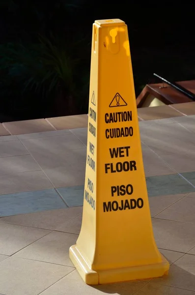 Cone de aviso de piso molhado amarelo — Fotografia de Stock