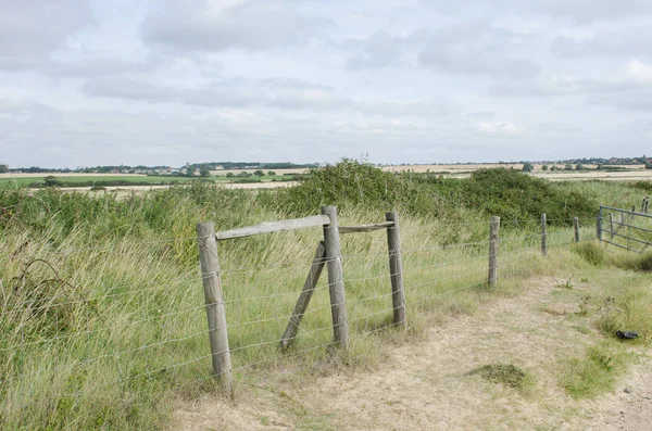 Wooden structure on flat land with fields behind