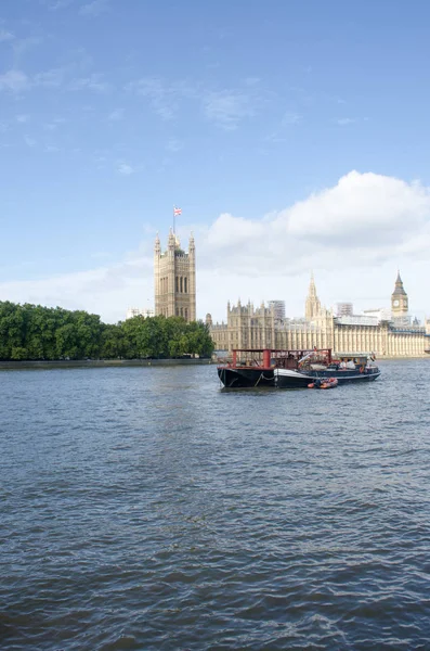 Řeka Temži s lodí a parlamentem v pozadí — Stock fotografie