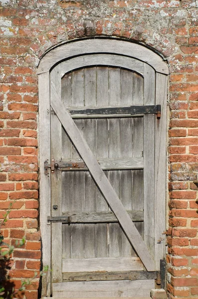 Stare malowane drewniane drzwi w mur z cegły — Zdjęcie stockowe