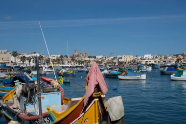 Marsaxlok Malta 9 February 2020: Maltese fishing village of Marsaxlokk with close up of  traditional painted boat in Foreground