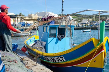Marsaxlok Malta 9 Şubat 2020: Marsaxlokk 'un Malta balıkçı köyü ve rıhtımda geleneksel boyalı tekne
