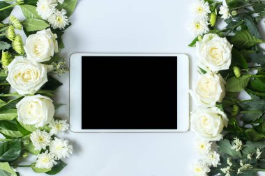 Taze beyaz gül çiçek ve beyaz zemin üzerine tablet