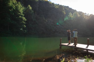 İki onlar iskelede dürbün ile izlerken kuş mans