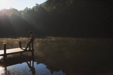 Ahşap köprü üzerinde rahatlatıcı bir adamdı.