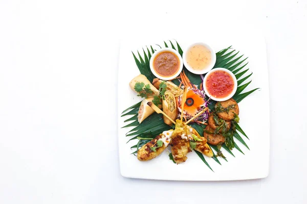 Poulet satay et boulettes de pâte de poisson frites et rouleaux de printemps — Photo