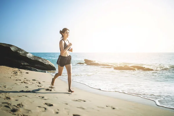 Young fitness woman running on the beach — Stock Photo, Image