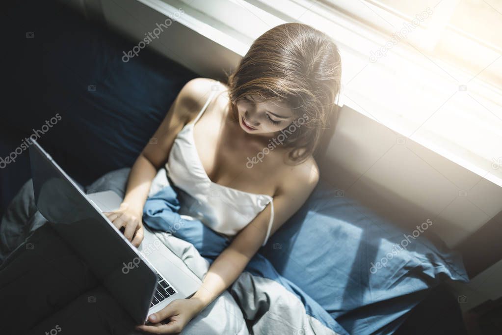 woman using laptop on the bed 