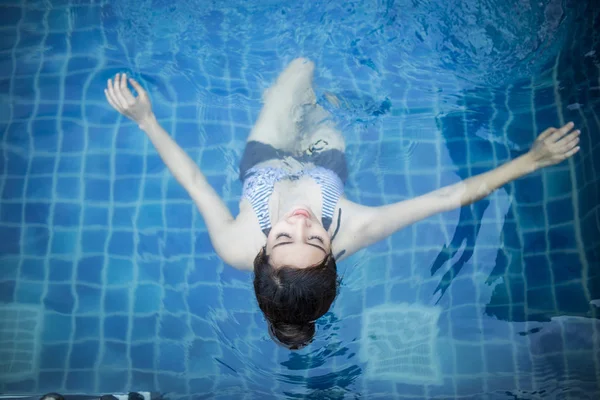 Mooie vrouw zwemmen in het zwembad. — Stockfoto