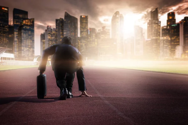 Businessman on a track ready for race in business — Stock Photo, Image