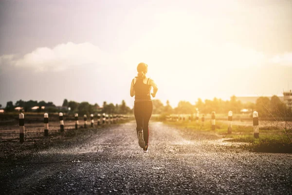 Jovem mulher fitness correndo na estrada pela manhã . — Fotografia de Stock