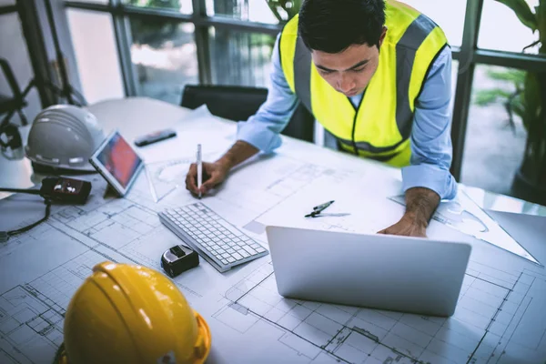 Mimar blueprint.engineer Müfettiş işyerinde - mimari proje, planları, cetvel, hesap makinesi, laptop ve bölücü pusula üzerinde çalışıyor. İnşaat kavramı. Mühendislik araçları, konsept çalışma.