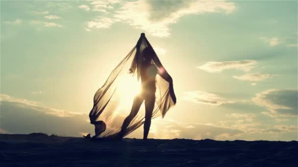 Gün batımında dans eden bir kadın silüeti — Stok video