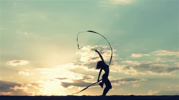 Silhueta de uma mulher dançante ao pôr do sol — Vídeo de Stock