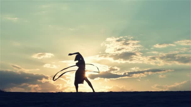 Silueta de una mujer bailando al atardecer — Vídeos de Stock