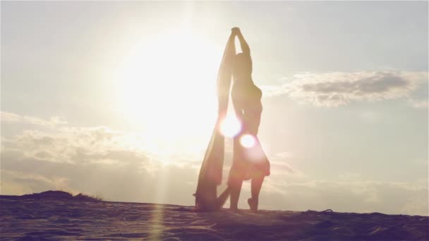 Silhouet van een dansende vrouw bij zonsondergang — Stockvideo