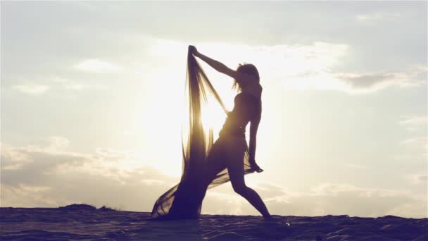 Silueta de una mujer bailando al atardecer — Vídeo de stock