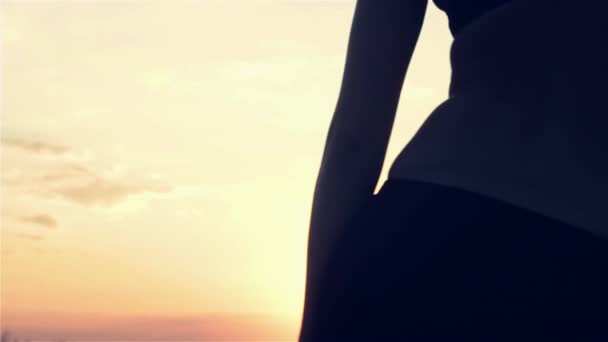 Gün batımında dans eden bir kadın silüeti — Stok video