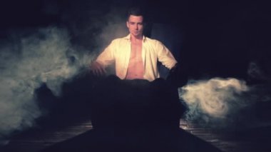 Seksi adam duman bir koltukta oturuyor.