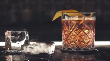 Barın üstünde buz küpleri olan kokteyl.
