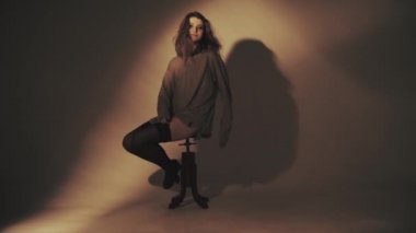 Çoraplı sandalyede oturan güzel kadın.