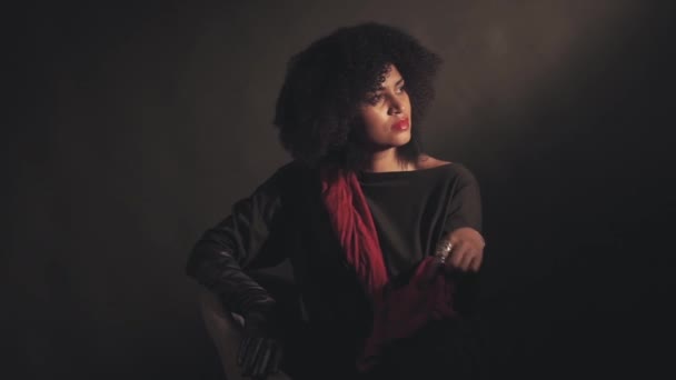 Woman in red scarf sits in chair — Stock Video