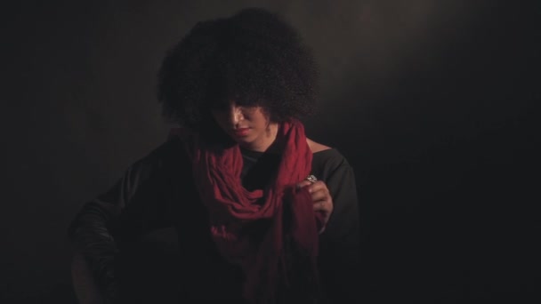 Frau mit rotem Schal sitzt auf Stuhl — Stockvideo